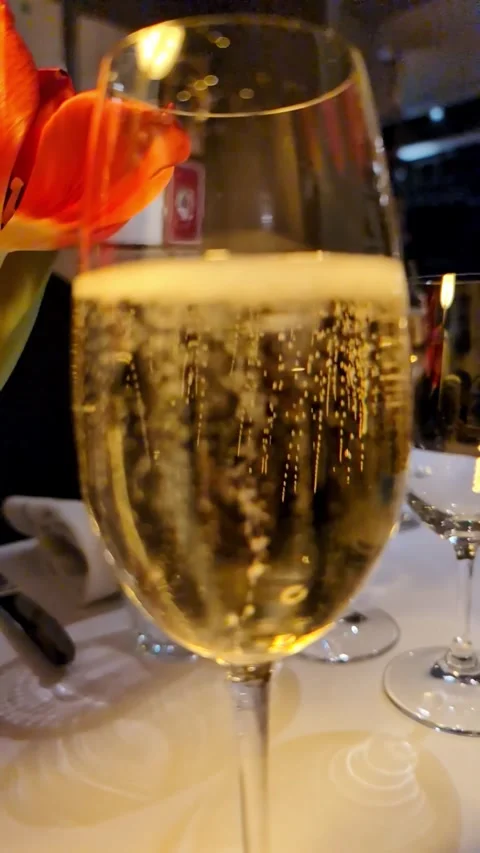 Champagne bubbles in wine glass at romantic anniversary dinner Video stock 335636626