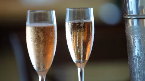 Champagne bubbling in two glasses with blurred background. rack focus Stock Footage 107272103