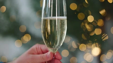 Champagne flute, bubbles glistening, against a radiant Christmas tree. Stock Footage 253263953