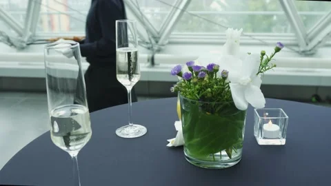 Champagne glasses, minimalistic table set and a caterer in the background Stock Footage 224315151