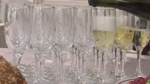 Champagne glasses on the table, half filled with champagne from a bottle in Vídeos de archivo 200029669
