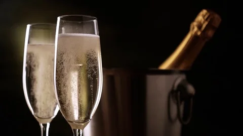 Champagne. Two Flutes with bottle of champagne in an ice bucket at background. Stock Footage 80802495