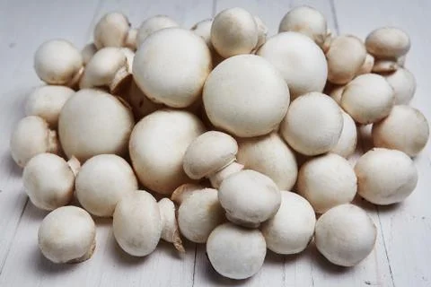 Champignon mushrooms on a white wooden background Stock Photos