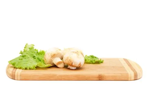 Champignons lying on cutting board Stock Photos