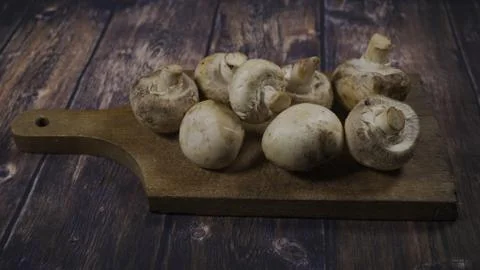 Champignons lying on a cutting board Stock Photos