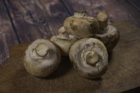 Champignons lying on a cutting board Stock Photos