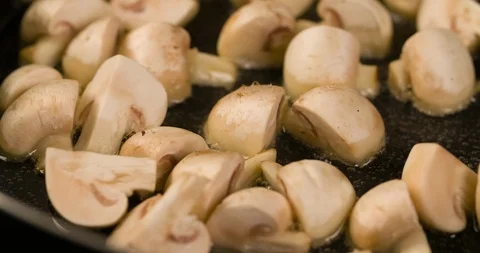 Champignons mushrooms roasting closeup Macro shot in Pan 4K Stock Footage 104060810