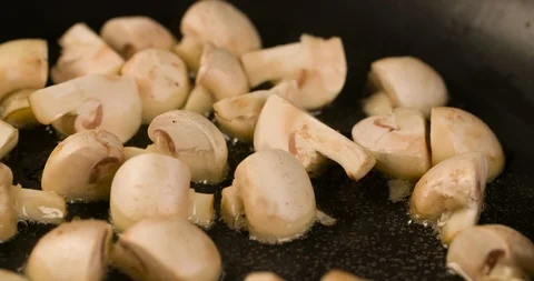 Champignons mushrooms roasting closeup Macro shot in Pan 4K Stock Footage 104060972