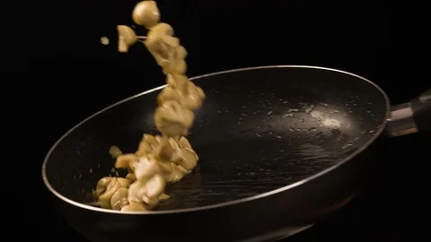 Champignons mushrooms roasting in Pan closeup Slow motion Stock Footage 104062704