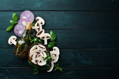 Champignons with spices on the old kitchen table. Top view. Free space for .. Stock Photos