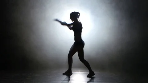 Champion boxer sends the punches. Silhouette. Light from behind. Black Stock Footage