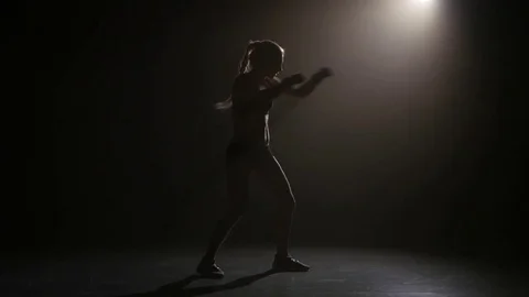 Champion boxer sends the punches. Silhouette. Lights rear. Black background Stock Footage