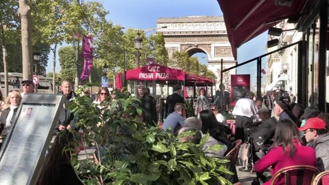 Champs Elysees with visitors  dining at cafes near the Arc de Triumphe in Paris Stock Footage 237096022