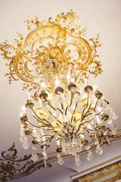 Chandelier with gold elements on the ceilings Stock Photos