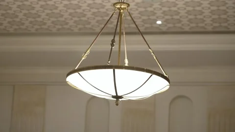 Chandelier hanging from ceiling in a bright room with patterned wallpaper Video stock 328989904