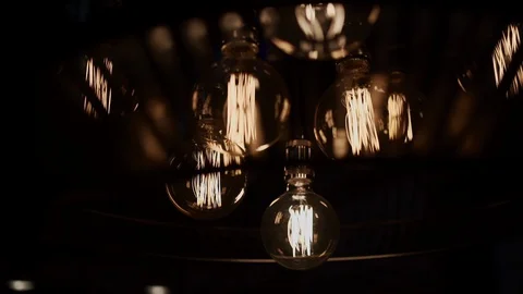 A chandelier hangs in the interior with stylized vintage light bulbs. Warm cozy  Stock Footage 127725341
