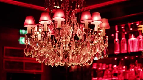 Chandelier with red lighting on the ceiling at a restaurant with shelves of Stock Footage 290384644