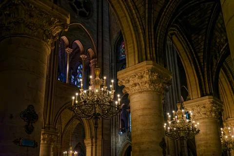 Chandeliers and stone columns inside Notre Dame Cathedral in Paris France Stock Photos