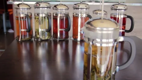 Change of focus from the French press in front to the teapots in the background Stock Footage