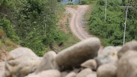 Change of Focus from Pile of Rocks to Uphill Dirt Road Stock Footage 209806521