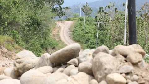 Change of Focus from Pile of Rocks to Uphill Dirt Road Stock-Footage 209806549