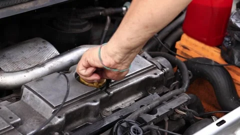 Change of oil. A man's hand opens or closes the oil filler cap Stock Footage 279491870