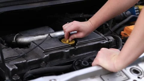 Change of oil. A woman's hand opens or closes the oil filler cap Stock Footage 279370068