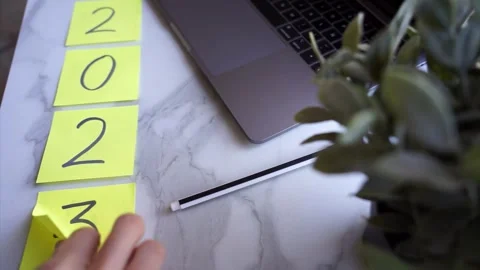 Change of year 2023 to 2024 with a hand changing a post-it Stock Footage 257064507