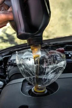 Changing the engine oil in the car engine with your own hands. A man pours .. Fotos de archivo