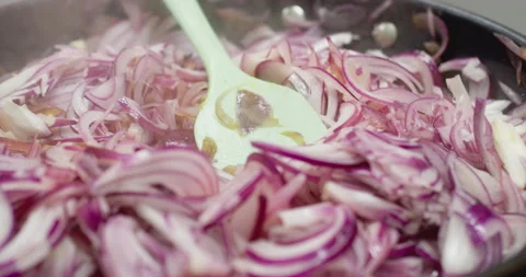Changing focus Sliced red onion in a frying pan on the stove Stock Footage 303629409
