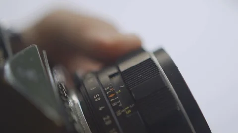 Changing focus by turning ring on old vintage 35mm film lens on SLR camera Stock-Footage 128844599