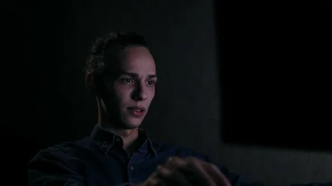 Changing focus from young man using computer to monitor an night Video stock 99932287