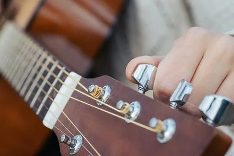 Changing guitar strings close up, tuning new strings of an acoustic guitar Stock Photos