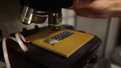 Changing lens on microscope in laboratory Video stock 81703591