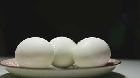 Changing Light and Shadows on White Eggs Against a Black Background Stock Footage 344671261