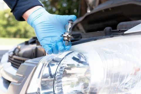 Changing light bulb in car headlight Stock Photos