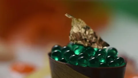 Changing lighting around mint capsules decorated with gold leaf. Stock Footage 132555233