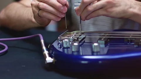 Changing old and broken bass guitars strings Video stock 111336676