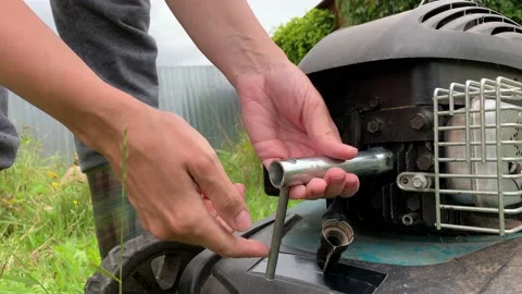 Changing replacing lawn mower spark plug, landscape equipment repair service Stock Footage 139990673