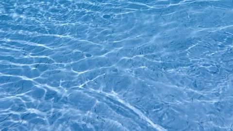 Changing ripple patterns on relaxing blue swimming pool water surface Stock Footage 246281744