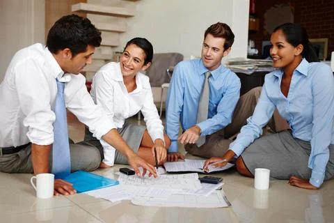 Changing their work routine up a bit. Four business colleagues going over the Stock Photos