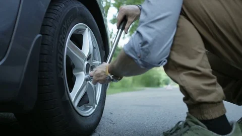 Changing a Tire. Hands of a Man Loosening Wheel Nuts Stock Footage 79889705