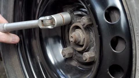 Changing a Tire with a Socket Wrench on a Black Rim, an essential automotive Stock Footage 309334060