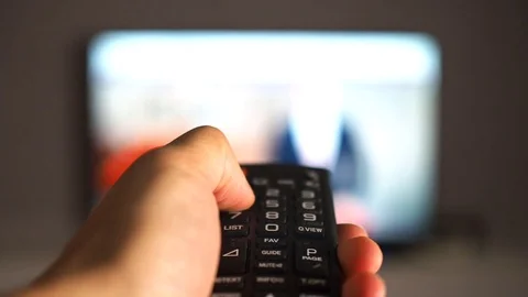Changing TV channels by remote. Focus on hand and remote Stock Footage 88772065