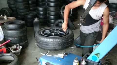 Changing tyre: Man inflating new tyre using air compressor Stock Footage 39216289