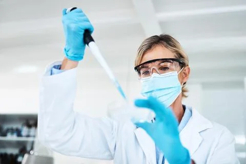 Changing variables while conducting tests. a scientist using a dropper and petri Fotos de archivo