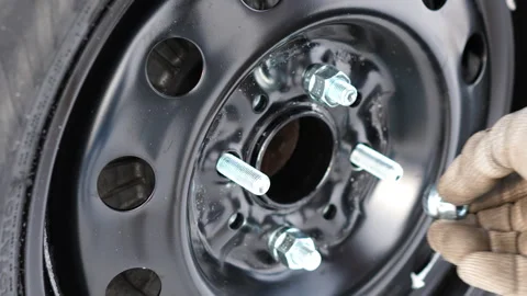 Changing winter tire on snowy ground during cold‑weather vehicle maintenance 库存影片 346501824