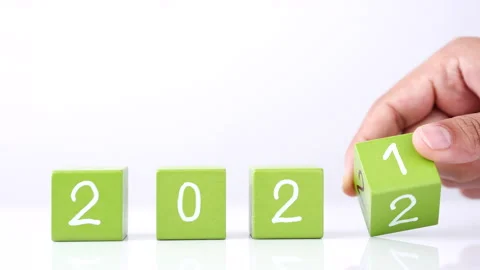 Changing year end 2021 to 2022. Close-up hand turns wooden cubes block Vídeo Stock 164104510