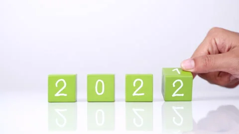 Changing year end 2021 to 2022. Close-up hand turns wooden cubes block Stock Footage 164105227