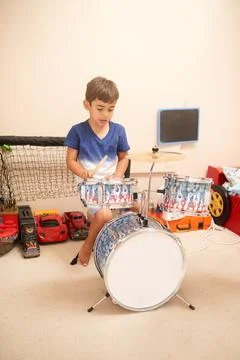 Channeling his inner drummer. a little boy playing with a drum set at home. Stock Photos